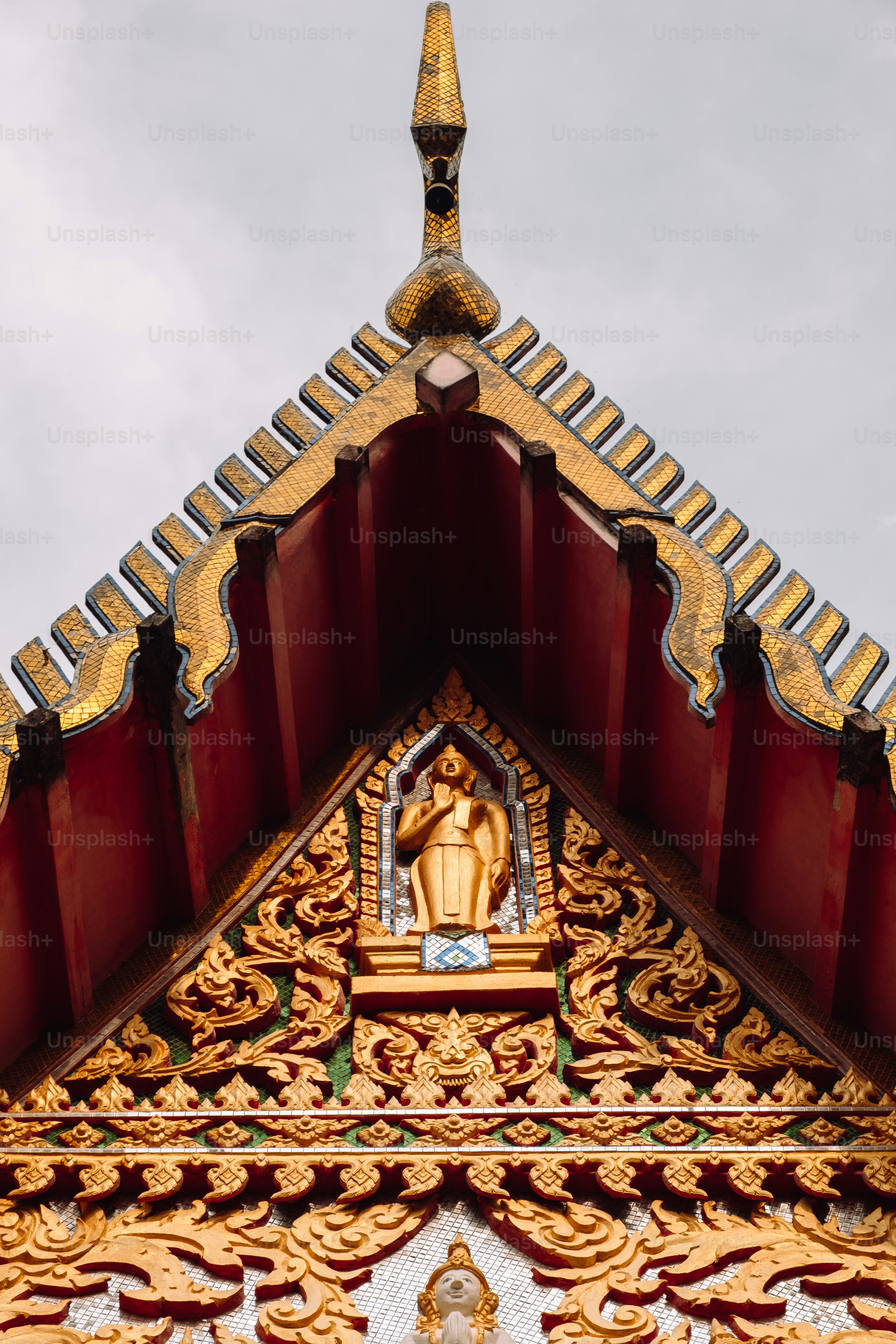 a gold and red building with a statue on top of it