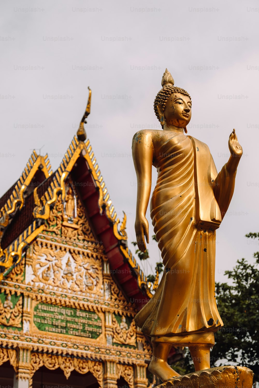 a golden buddha statue in front of a building