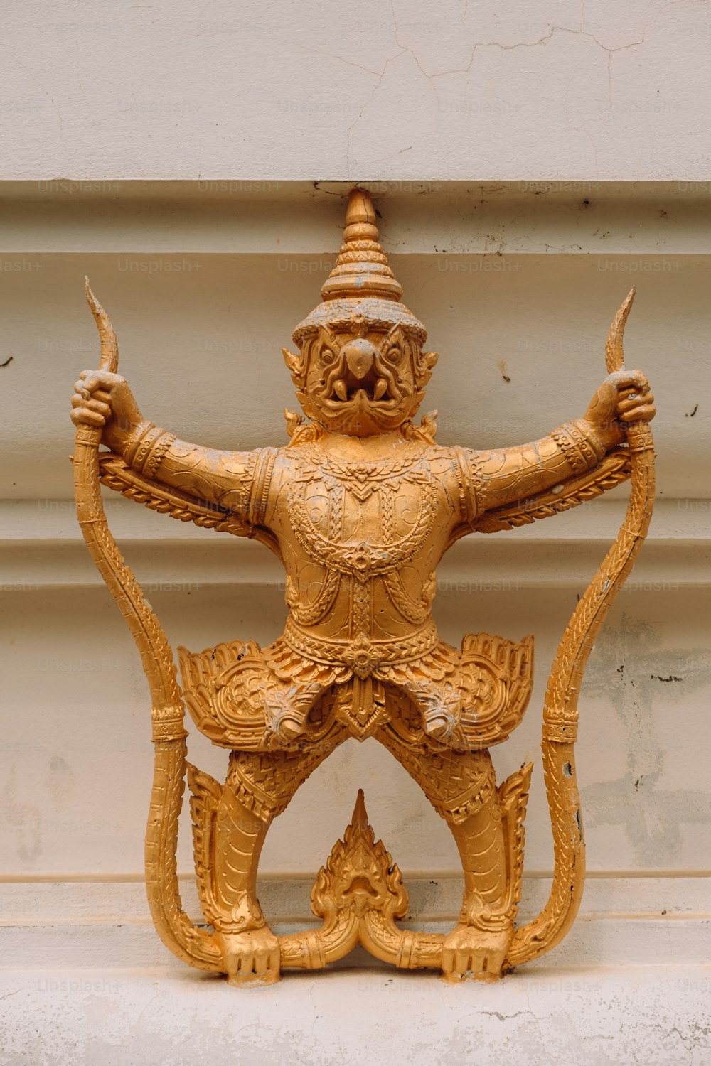 Una estatua dorada de un hombre sosteniendo un arco