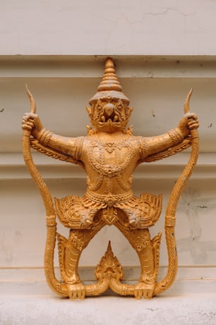 a golden statue of a man holding a bow