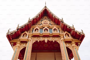 a red and gold building with a clock on it's side