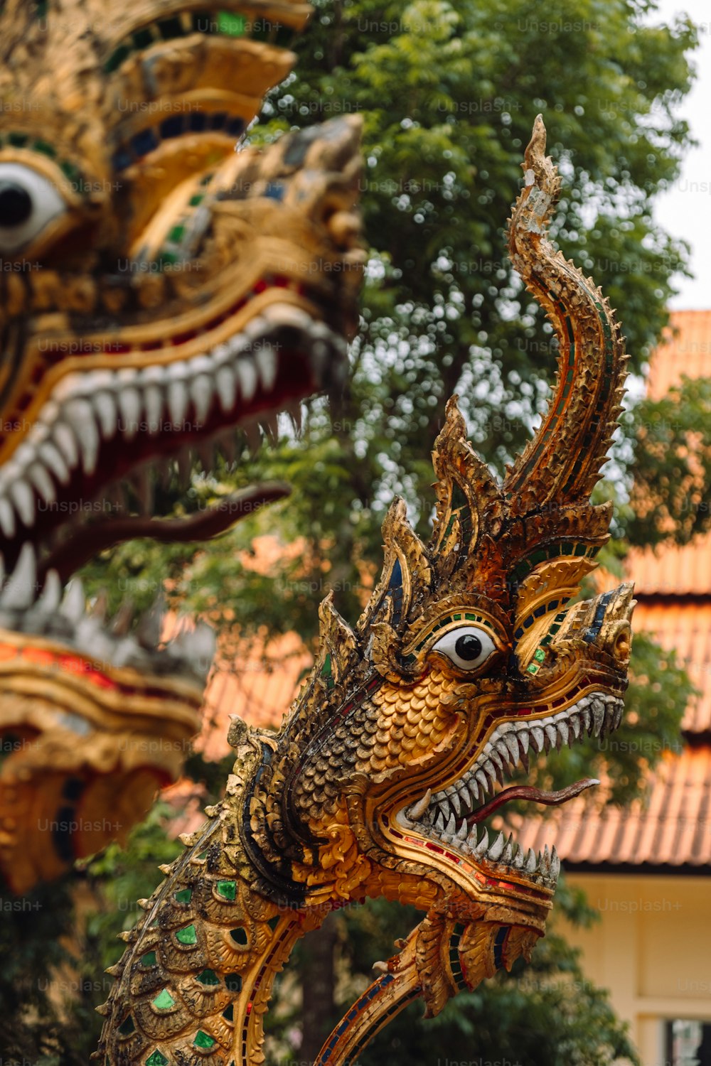 Un primer plano de una estatua de dragón frente a un edificio