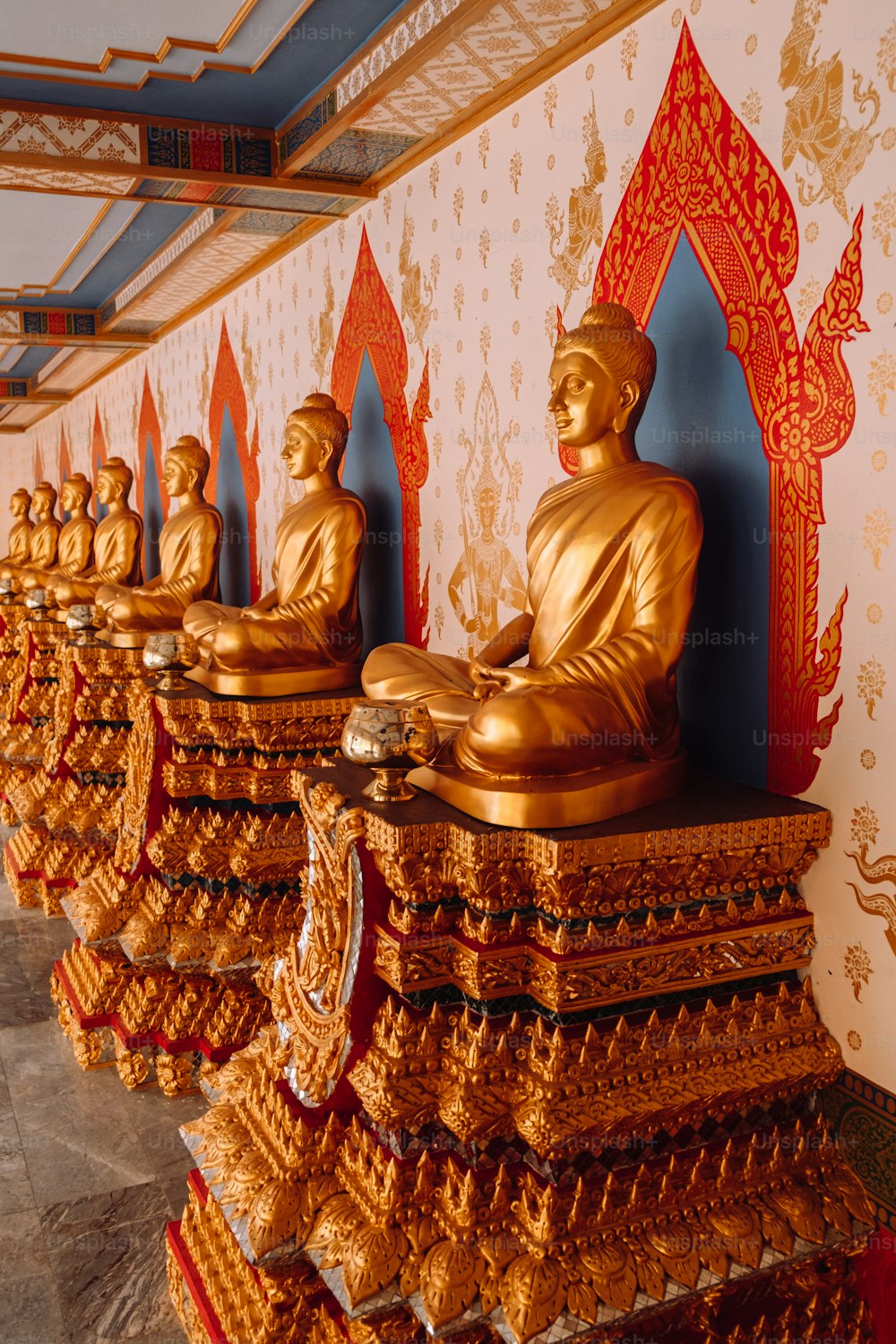a row of golden buddha statues in a room