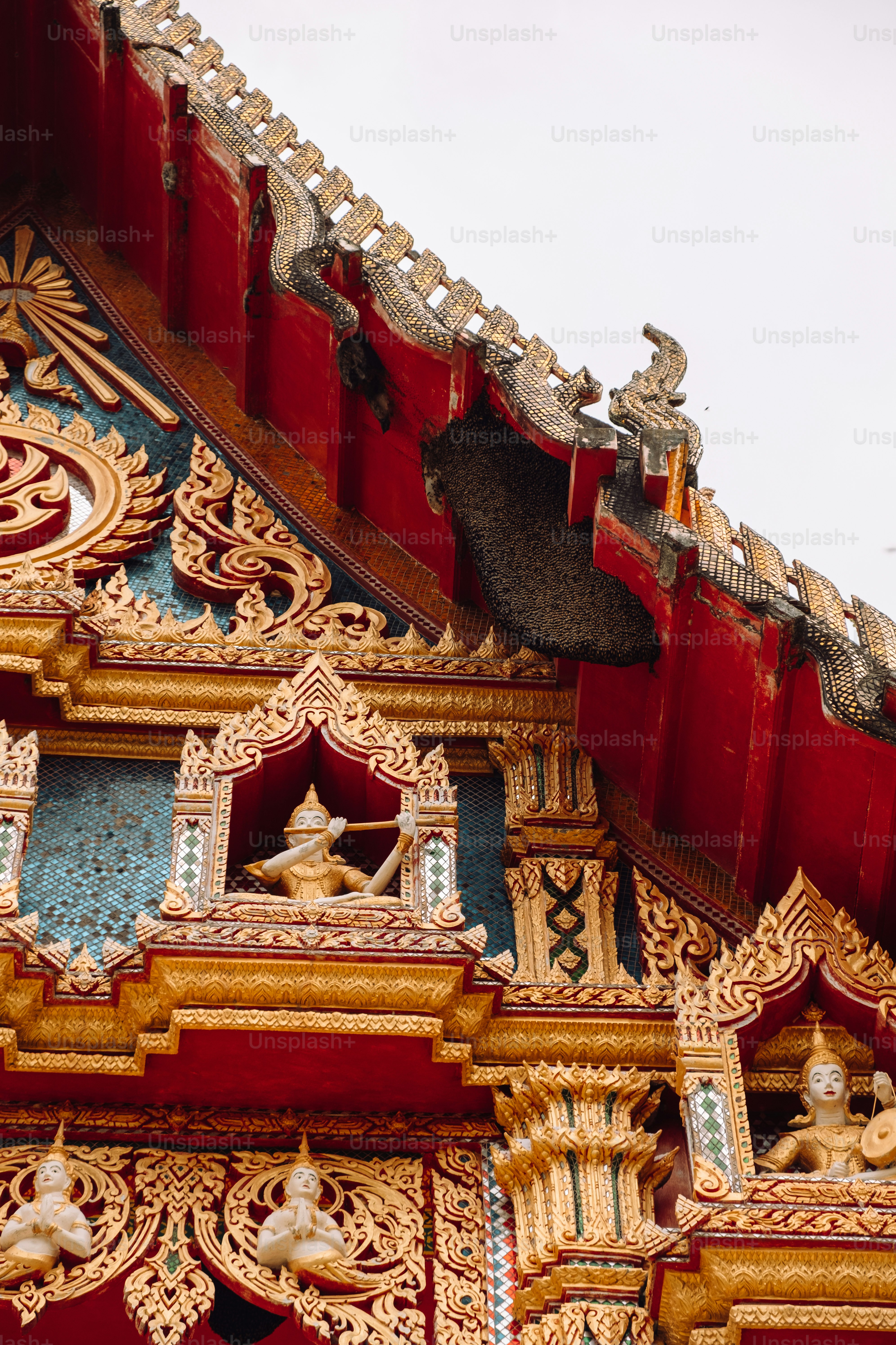 A red and gold building with statues on top of it photo – Compassion ...