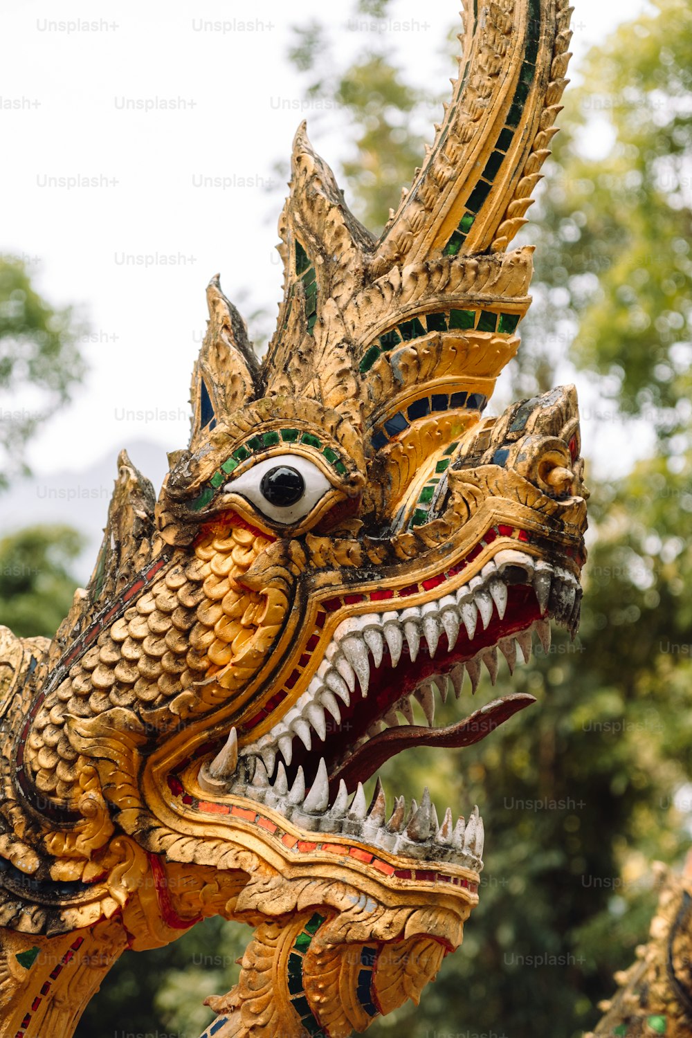 Una estatua de dragón dorado con una gran boca abierta