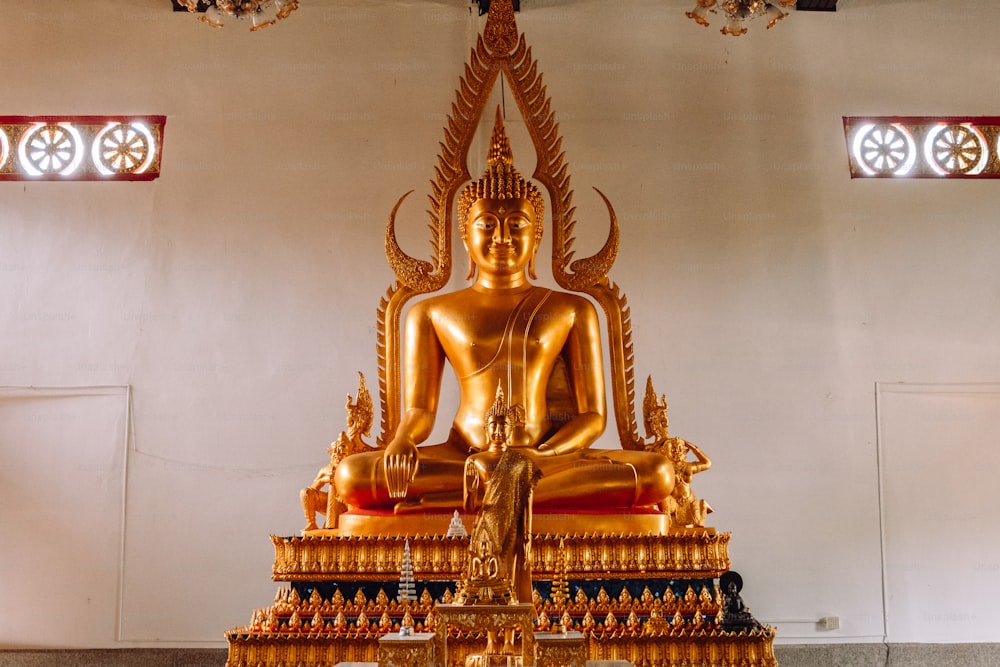 uma estátua dourada de Buda sentada em uma sala