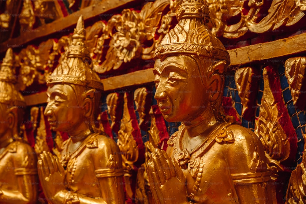 a row of golden statues sitting next to each other