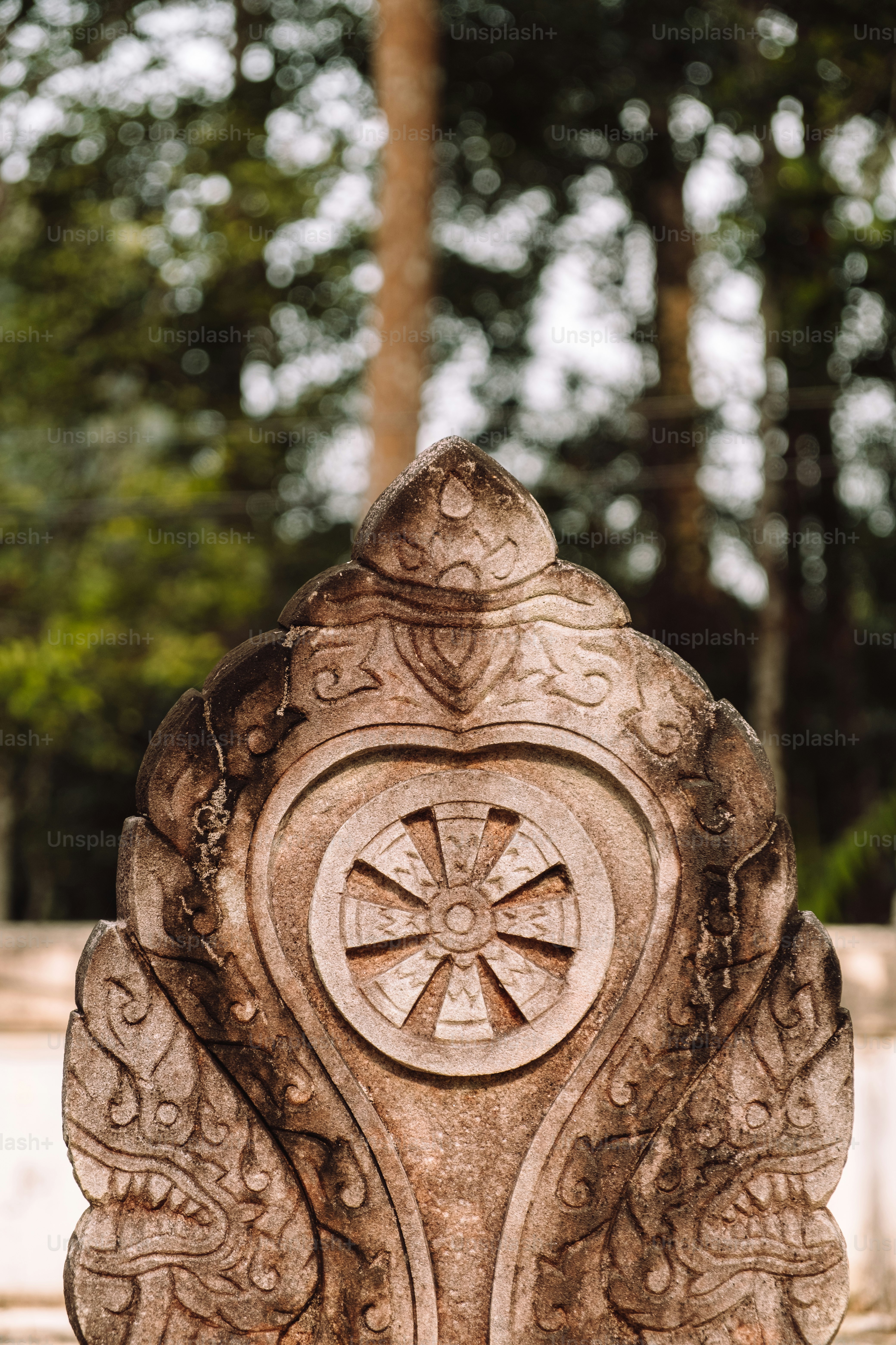 eine Steinstatue mit einem Kreuz darauf