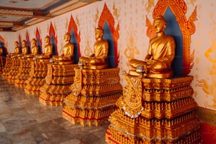 a row of golden buddha statues in a room