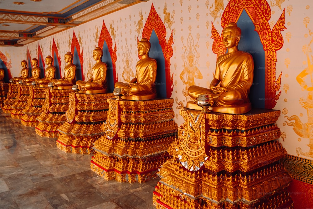 a row of golden buddha statues in a room