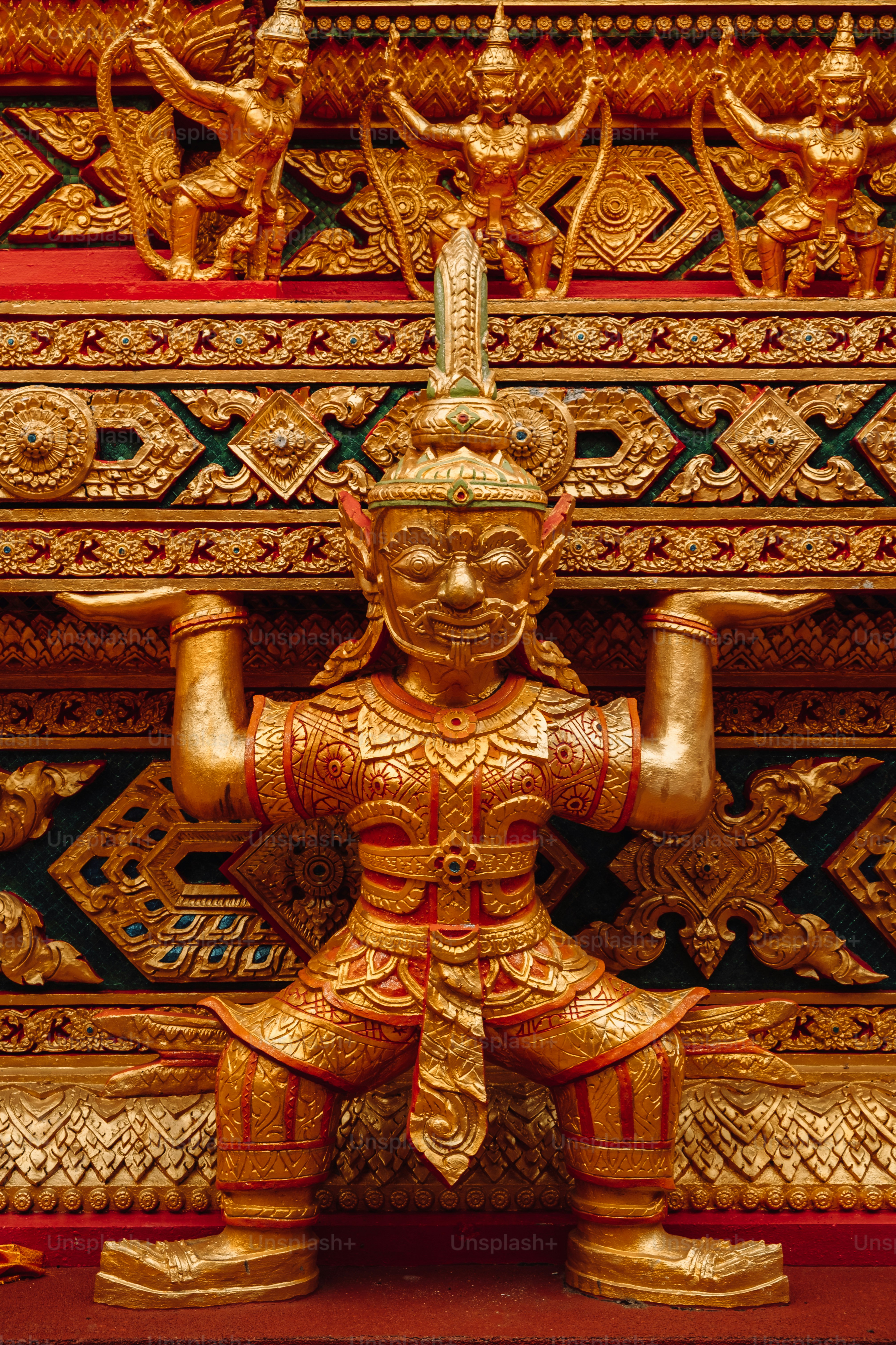 a golden statue of a person sitting on a bench