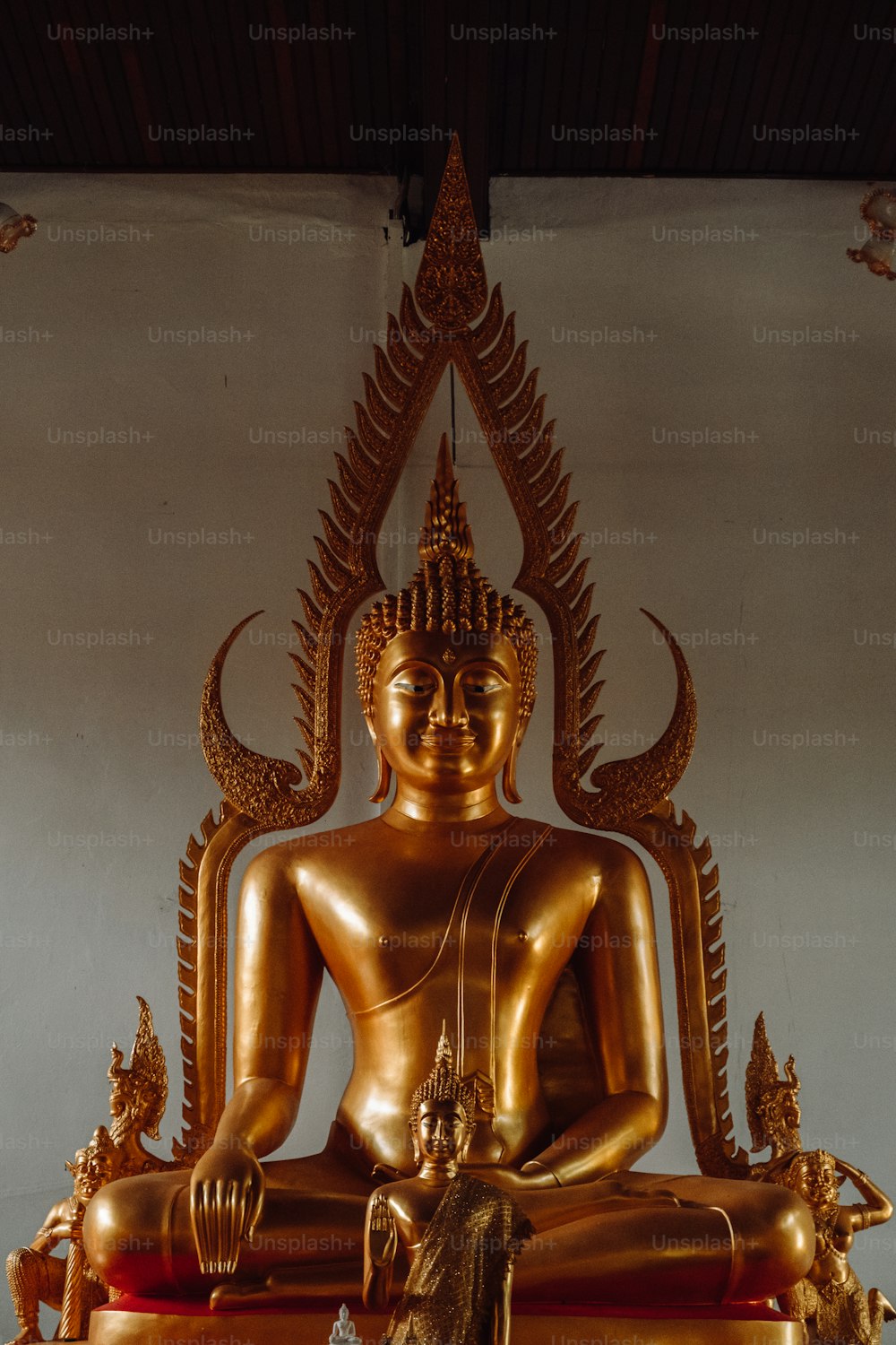 uma estátua dourada de Buda sentada em cima de uma mesa