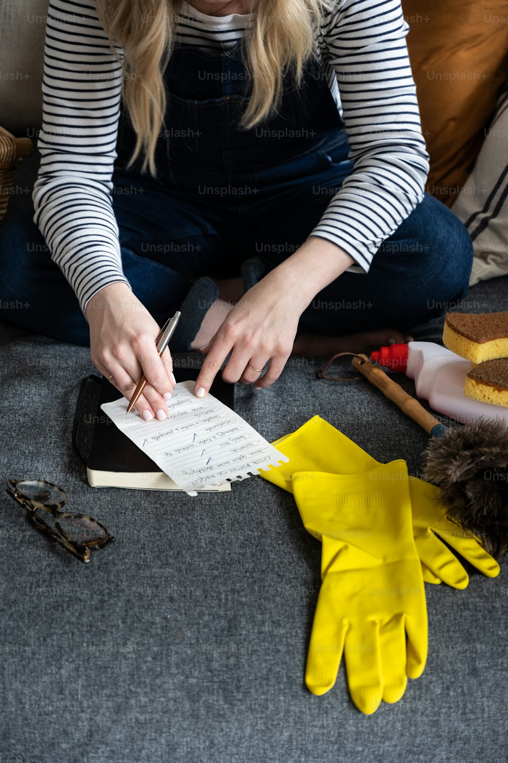 a woman sitting on a couch working on a project