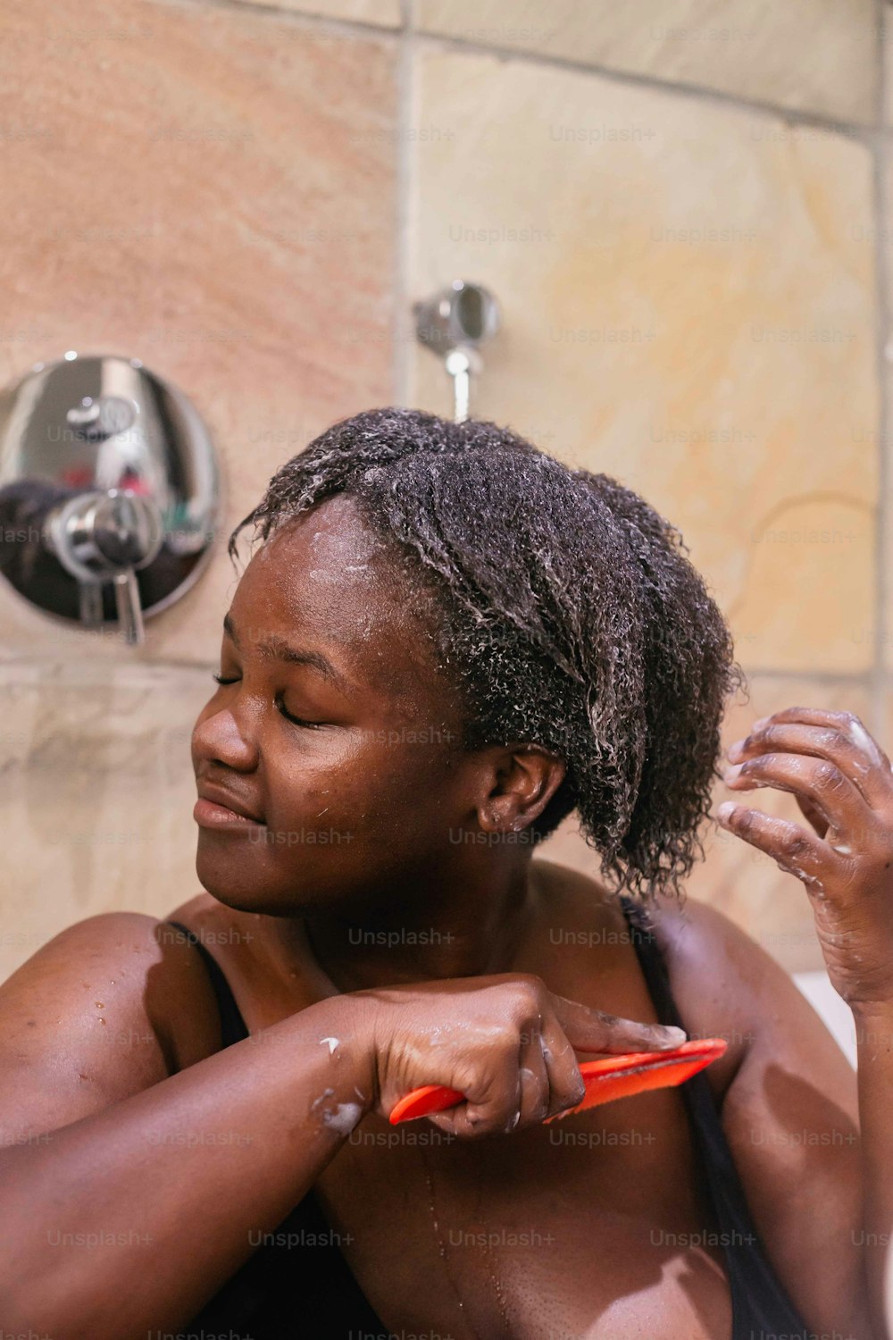uma mulher está escovando o cabelo no chuveiro