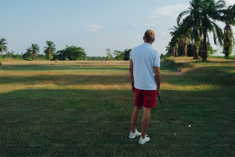 Ein Mann in weißem Hemd und roten Shorts beim Golfspielen