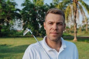 a man in a white shirt holding a golf club