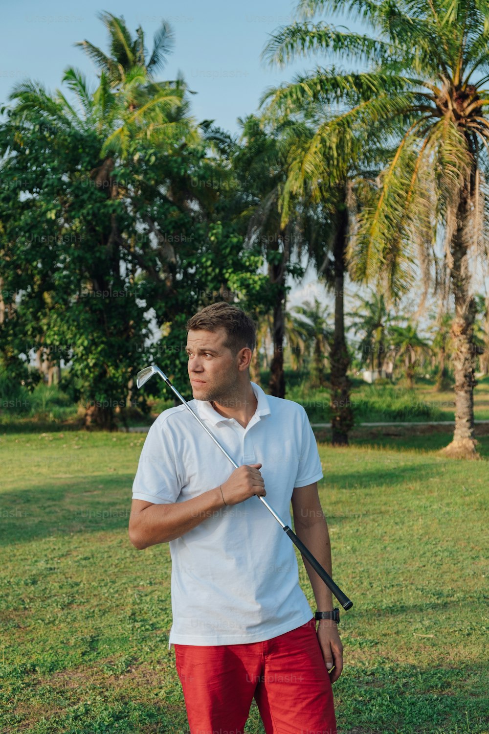 a man holding a golf club in a field