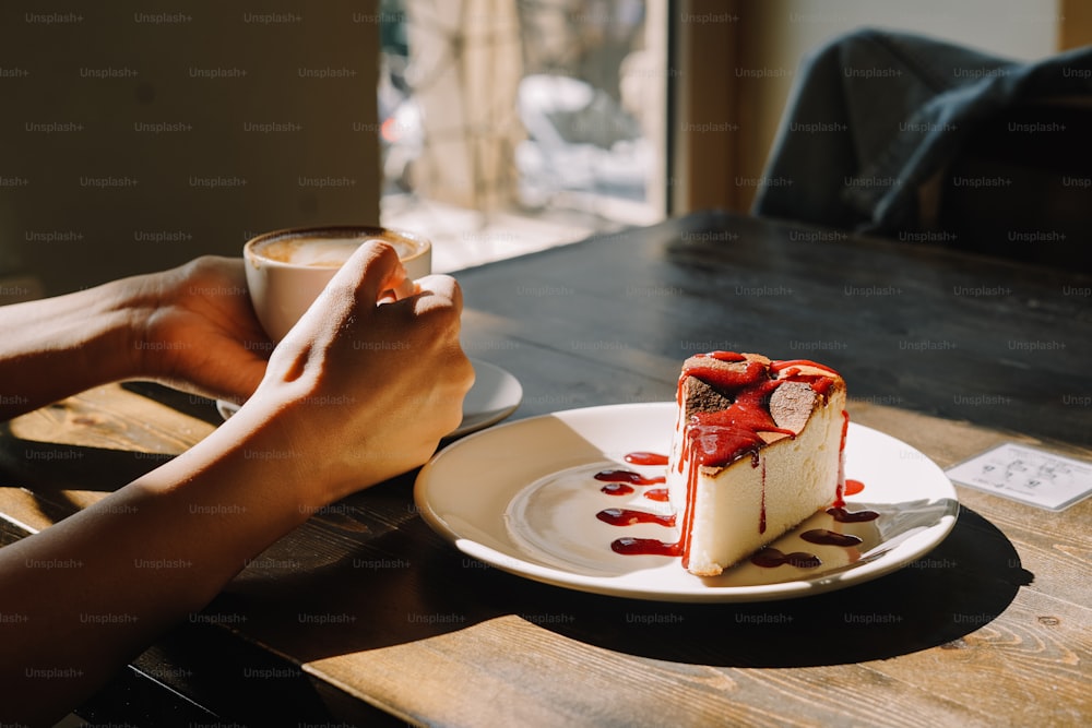 a piece of cheesecake on a plate with a cup of coffee