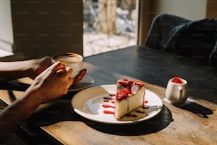 um pedaço de cheesecake em um prato com uma xícara de café