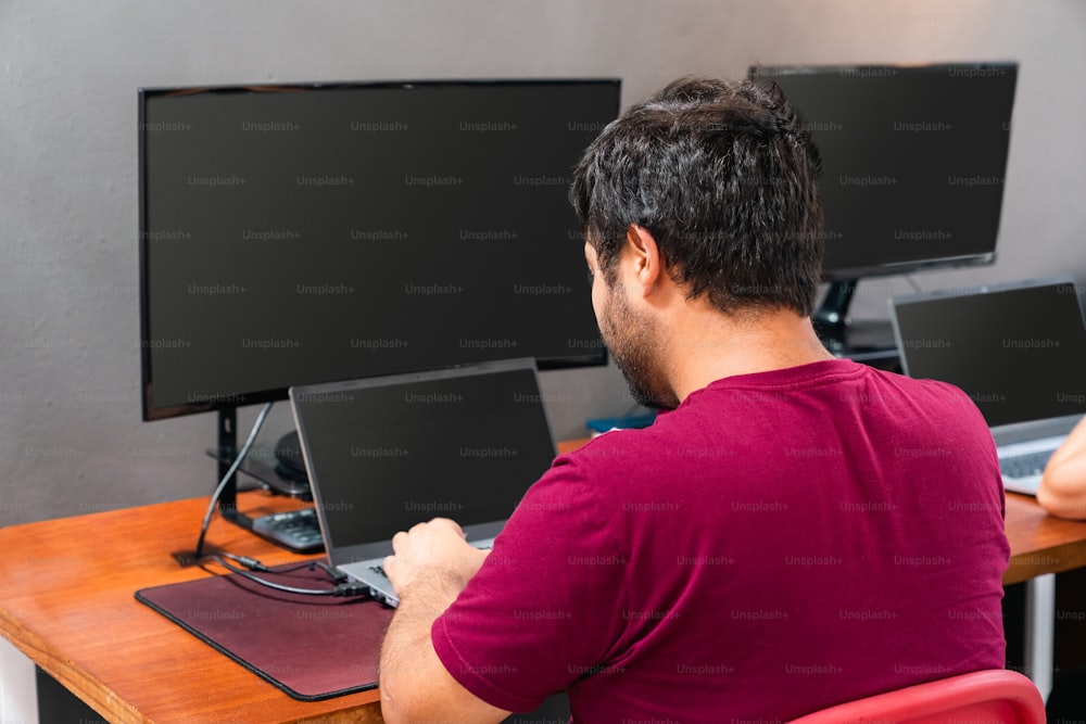 um homem sentado em uma mesa trabalhando em um computador