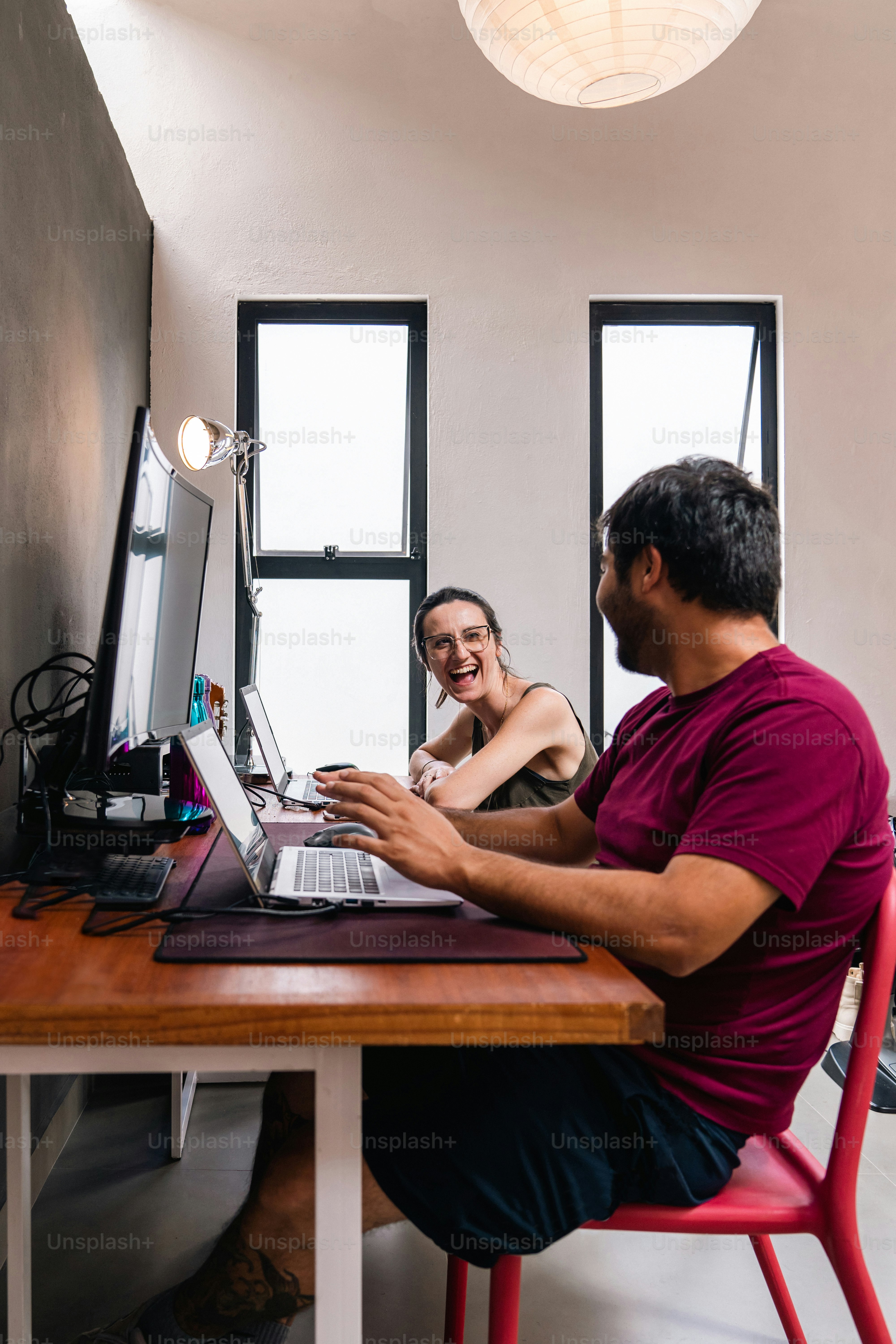 Un hombre sentado en un escritorio con una computadora portátil