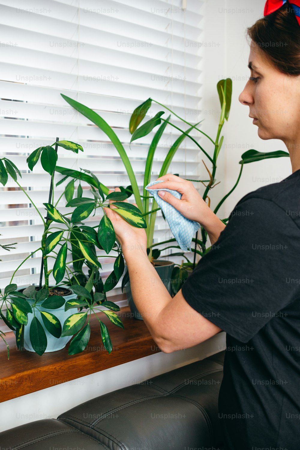 a woman is cleaning a window sill with a cloth