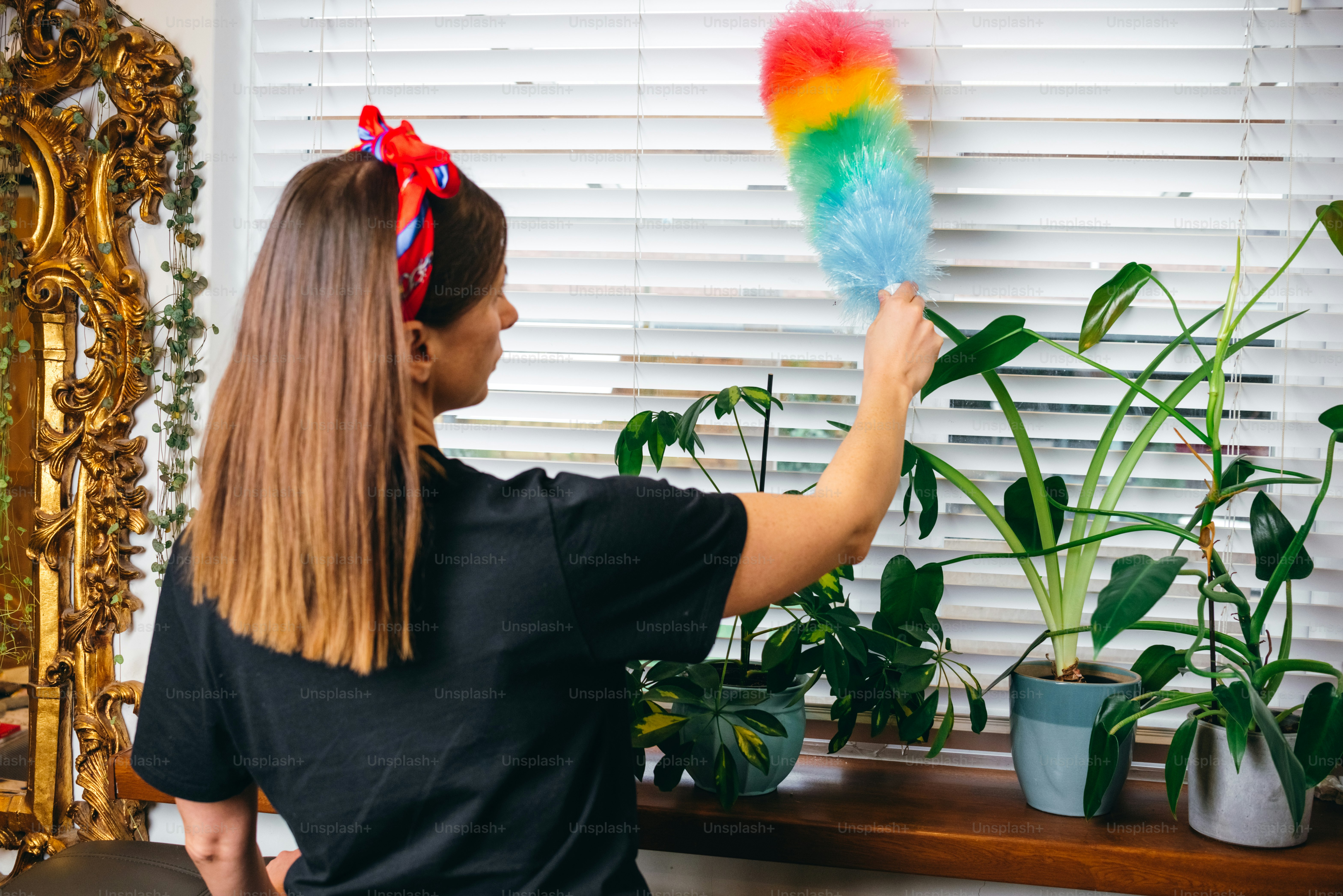 a woman in a black shirt is holding a colorful fan