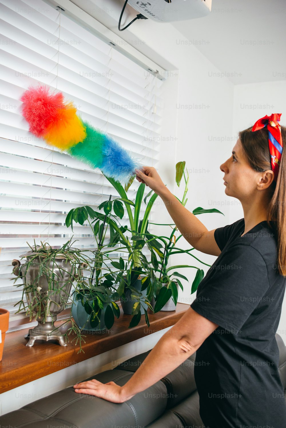 a woman in a black shirt is painting a window