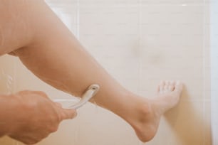 une personne utilise un sèche-cheveux sur ses jambes