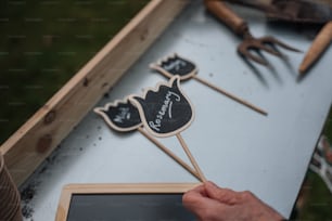 a person holding a wooden stick with a chalkboard on it