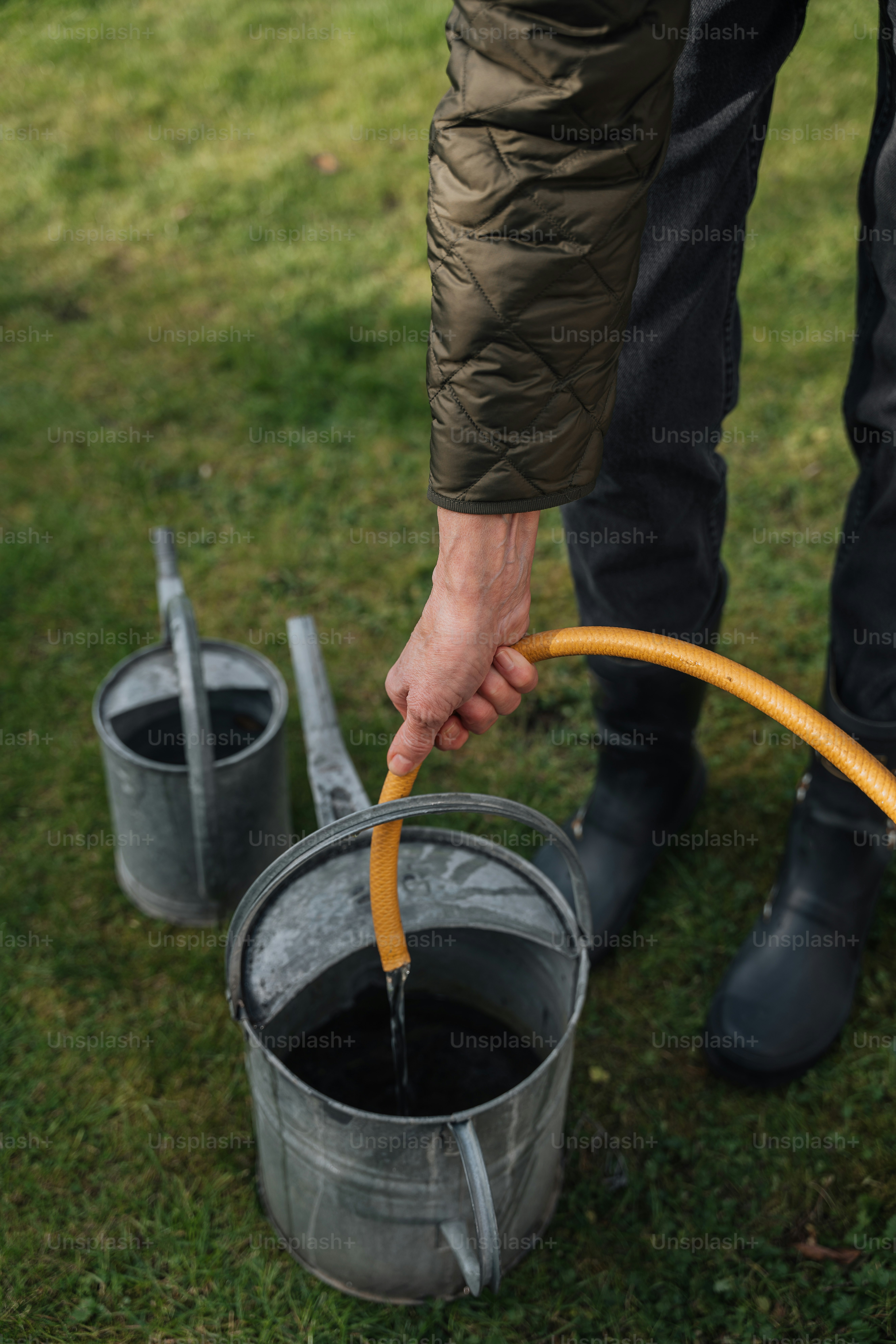 a person holding a hose in a bucket