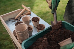 a person holding a shovel digging dirt in a garden
