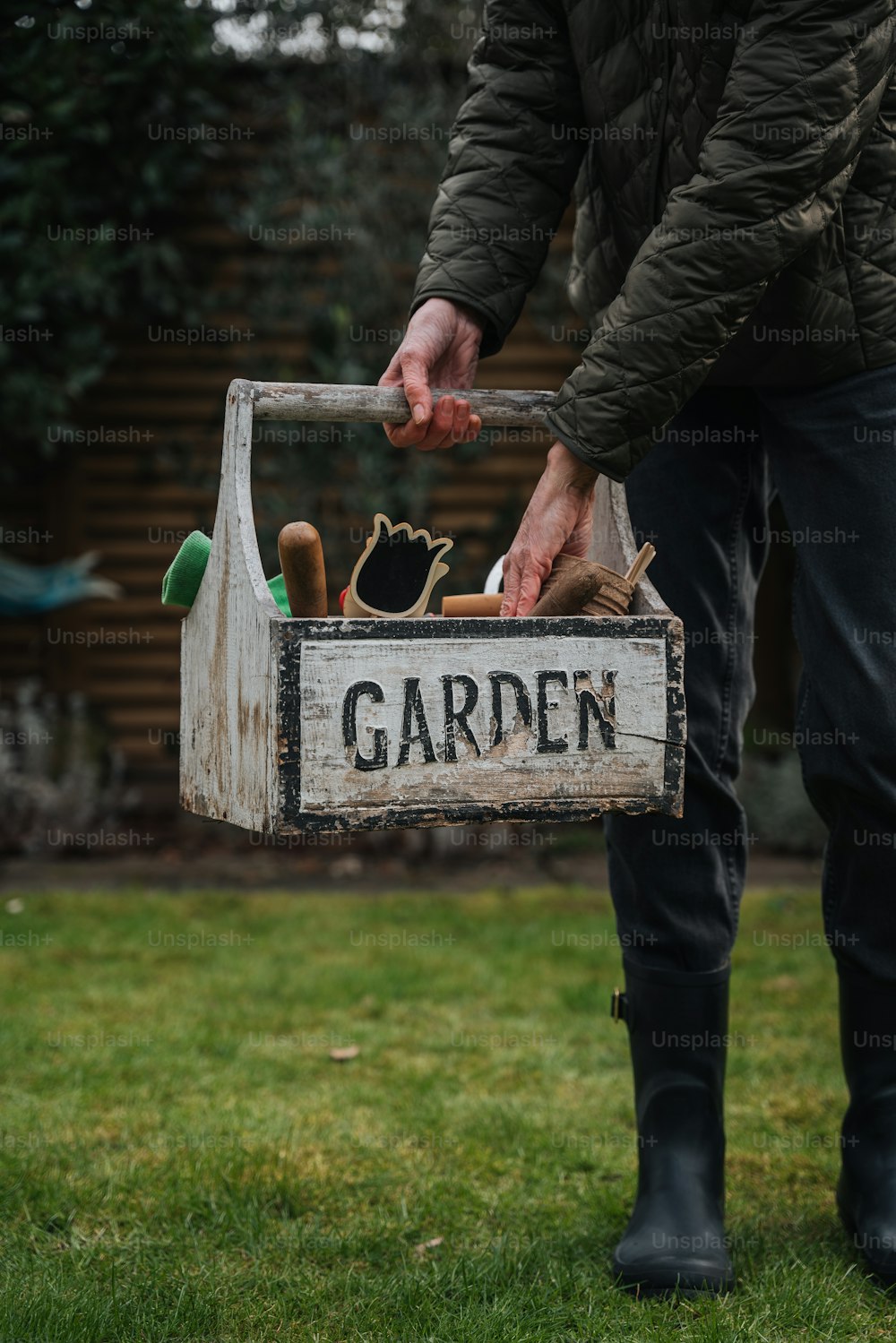 um homem está segurando uma caixa de jardim na grama