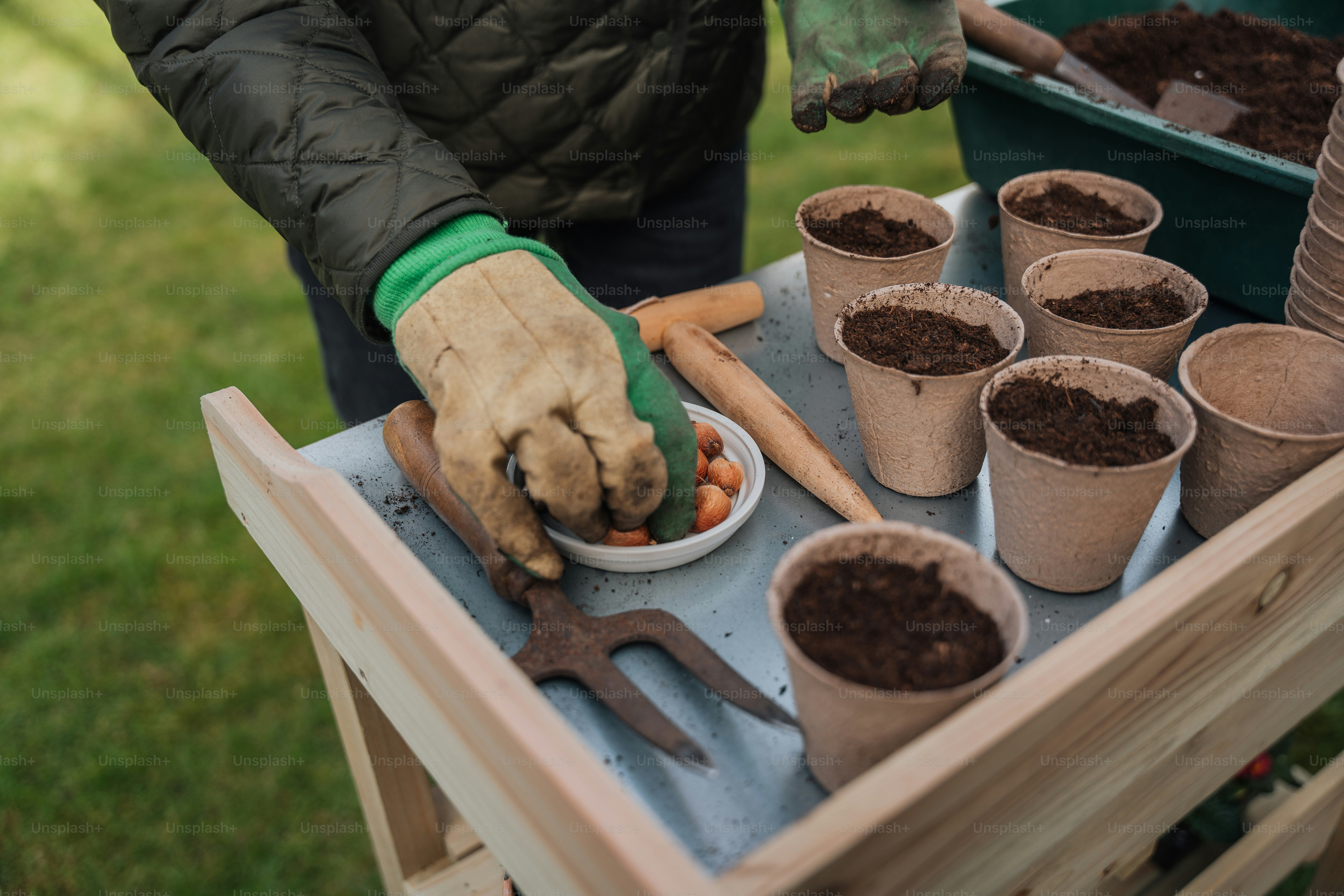 a person with gardening gloves and gardening utensils