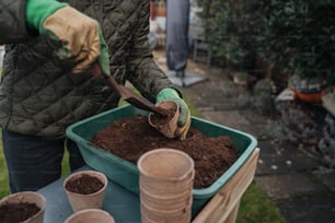 a person shoveling dirt into a container of dirt