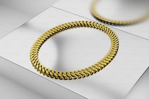 a close up of a gold bracelet on a white surface