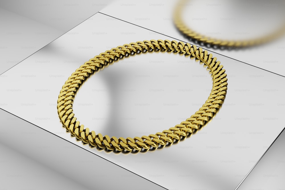 a close up of a gold bracelet on a white surface