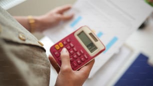 a person holding a red calculator in their hand