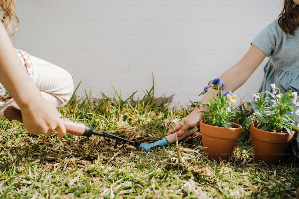 Una mujer y un niño están haciendo jardinería en la hierba