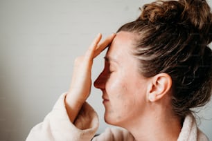 a woman with her hand on her forehead