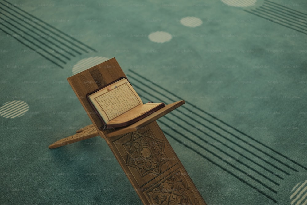 um livro aberto sentado em cima de um suporte de madeira