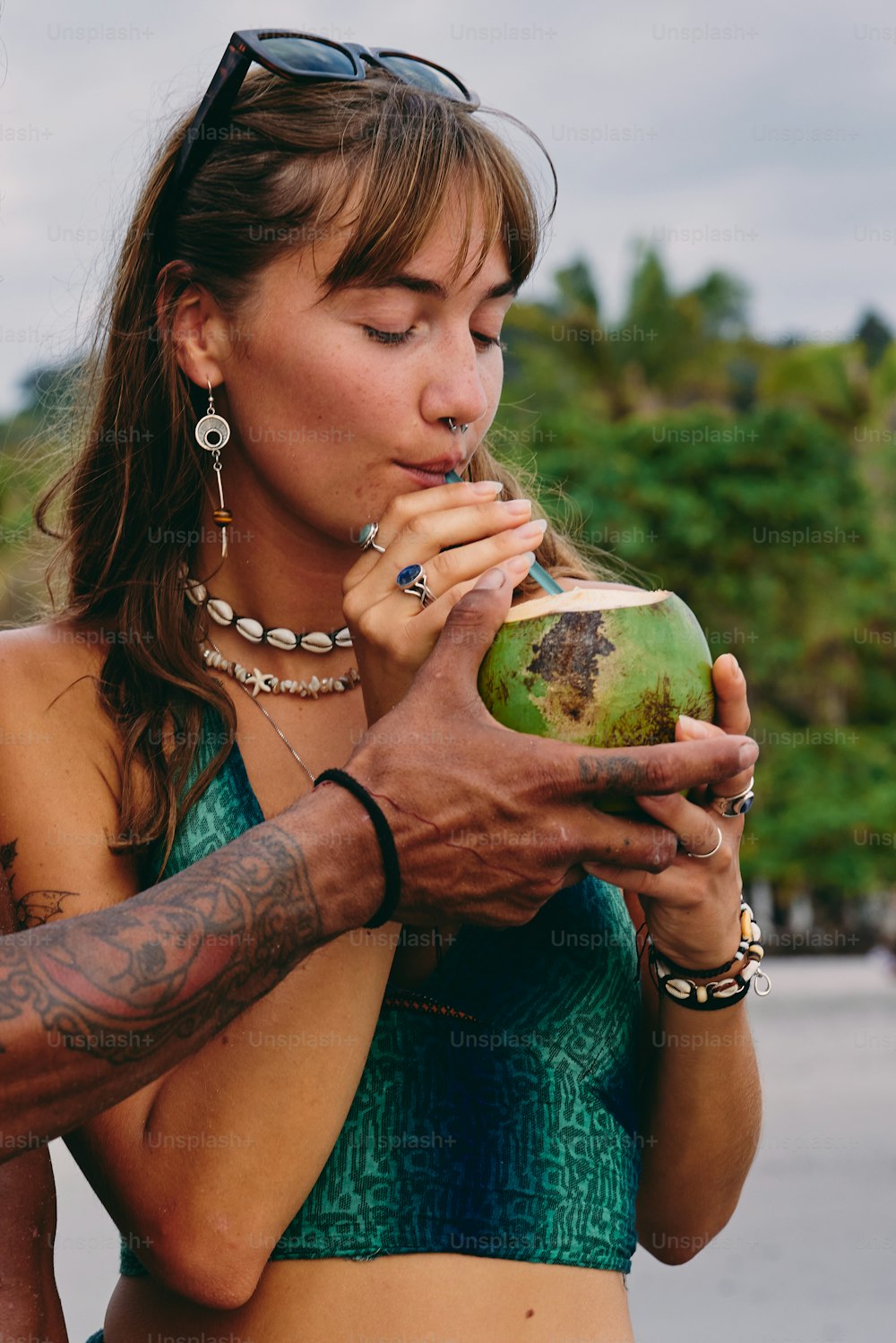 Una donna in bikini che beve da una noce di cocco