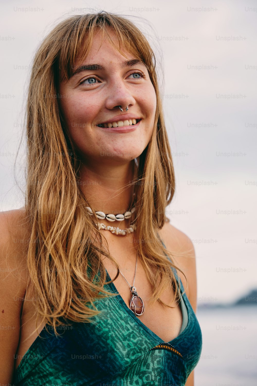 uma mulher em um top verde sorrindo para a câmera