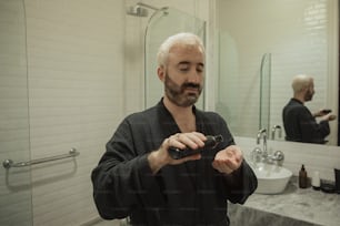 Ein Mann im Bademantel putzt sich im Badezimmer die Zähne