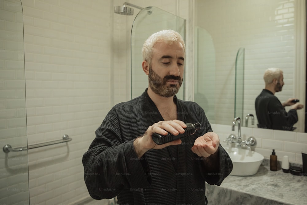 a man in a bathrobe brushing his teeth in a bathroom