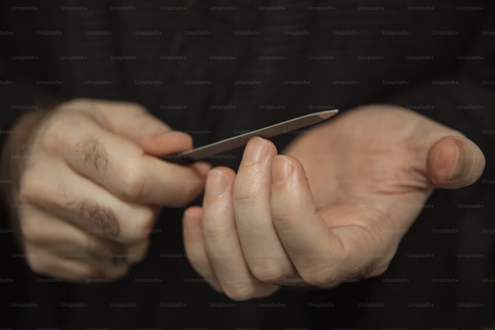 una persona sosteniendo un teléfono celular en sus manos