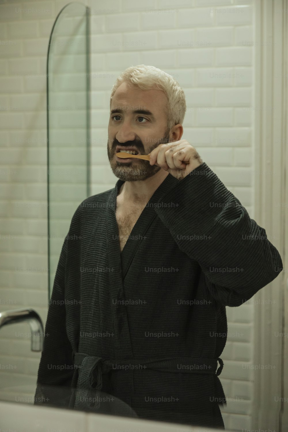 Un hombre cepillándose los dientes frente a un espejo