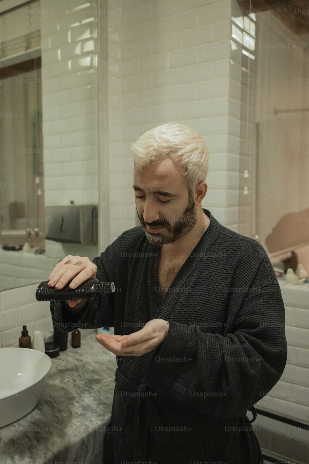 Ein Mann im Bademantel hält eine Flasche in der Hand