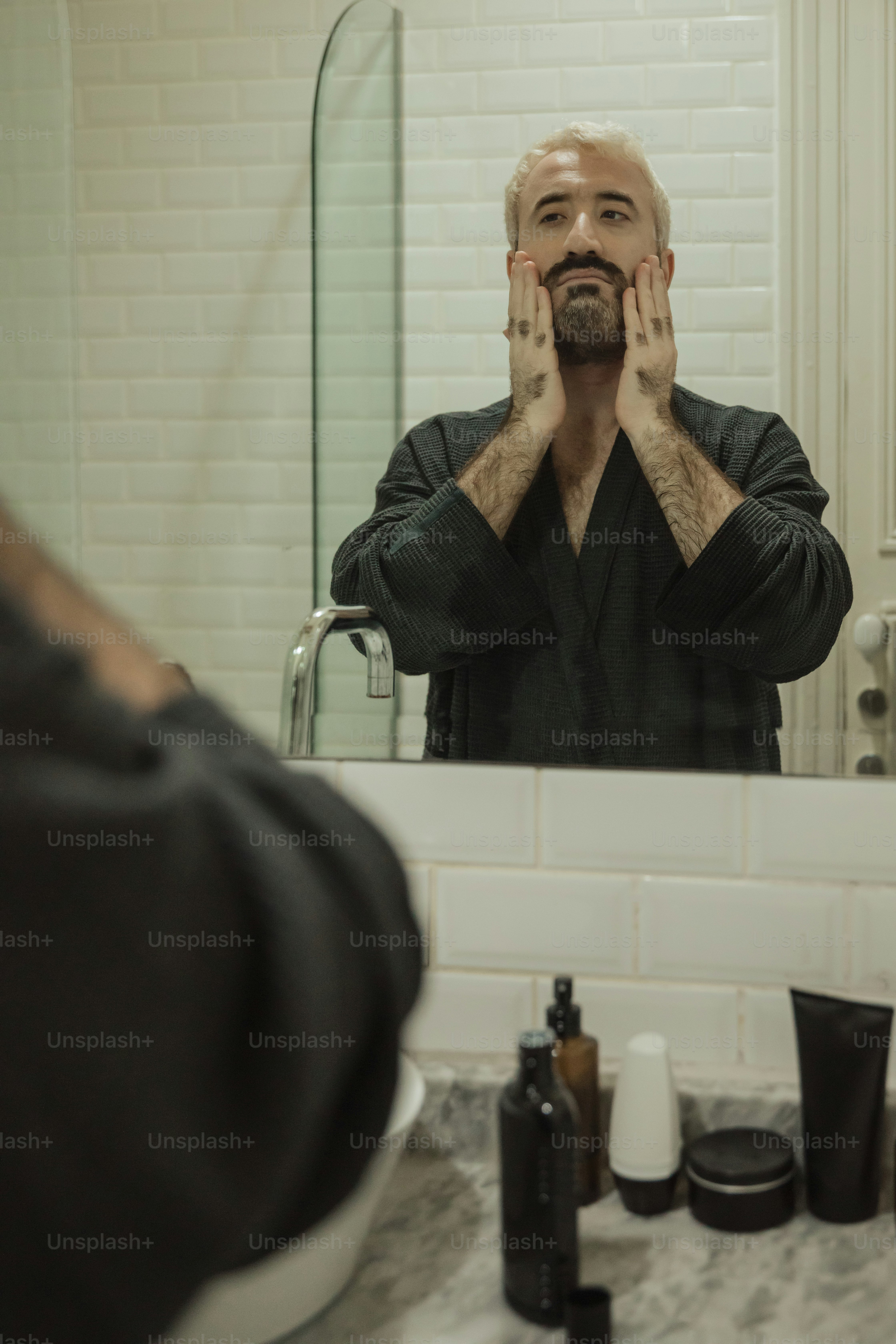 a man standing in front of a bathroom mirror