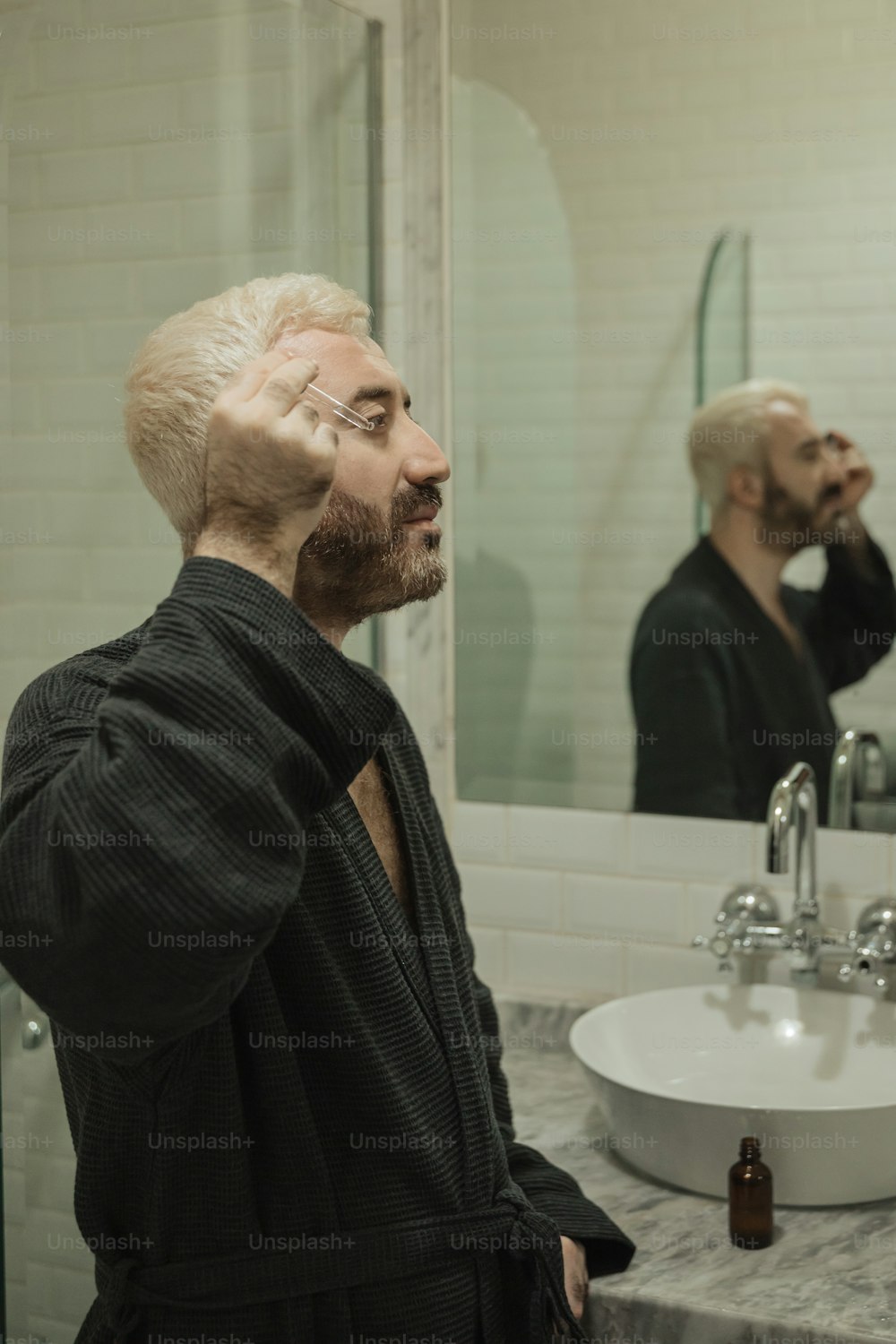 a man with a bald head standing in front of a bathroom mirror